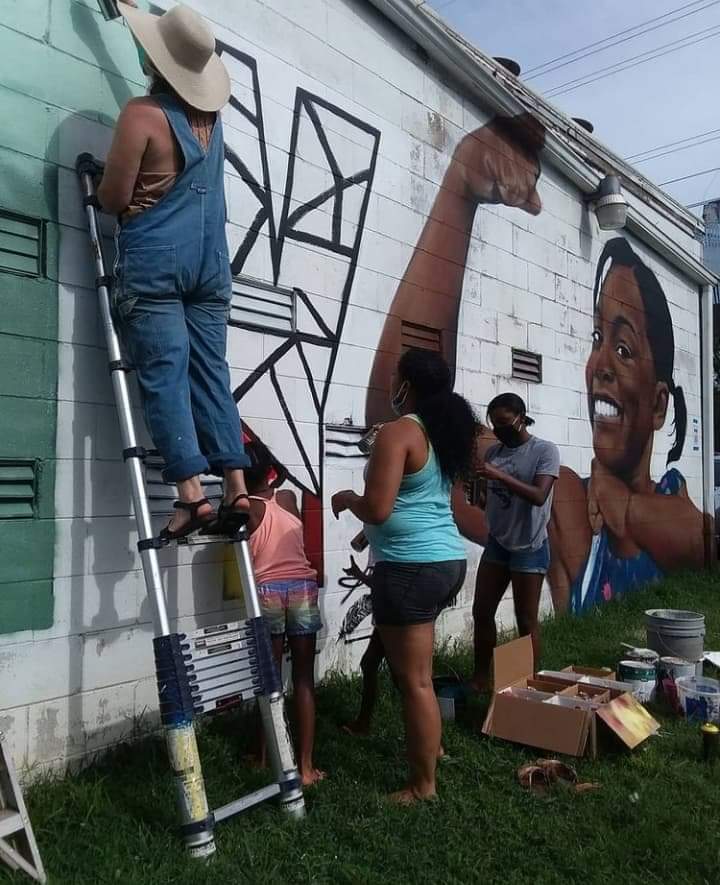 Samuel Hale and community helpers painting the Solidarity mural